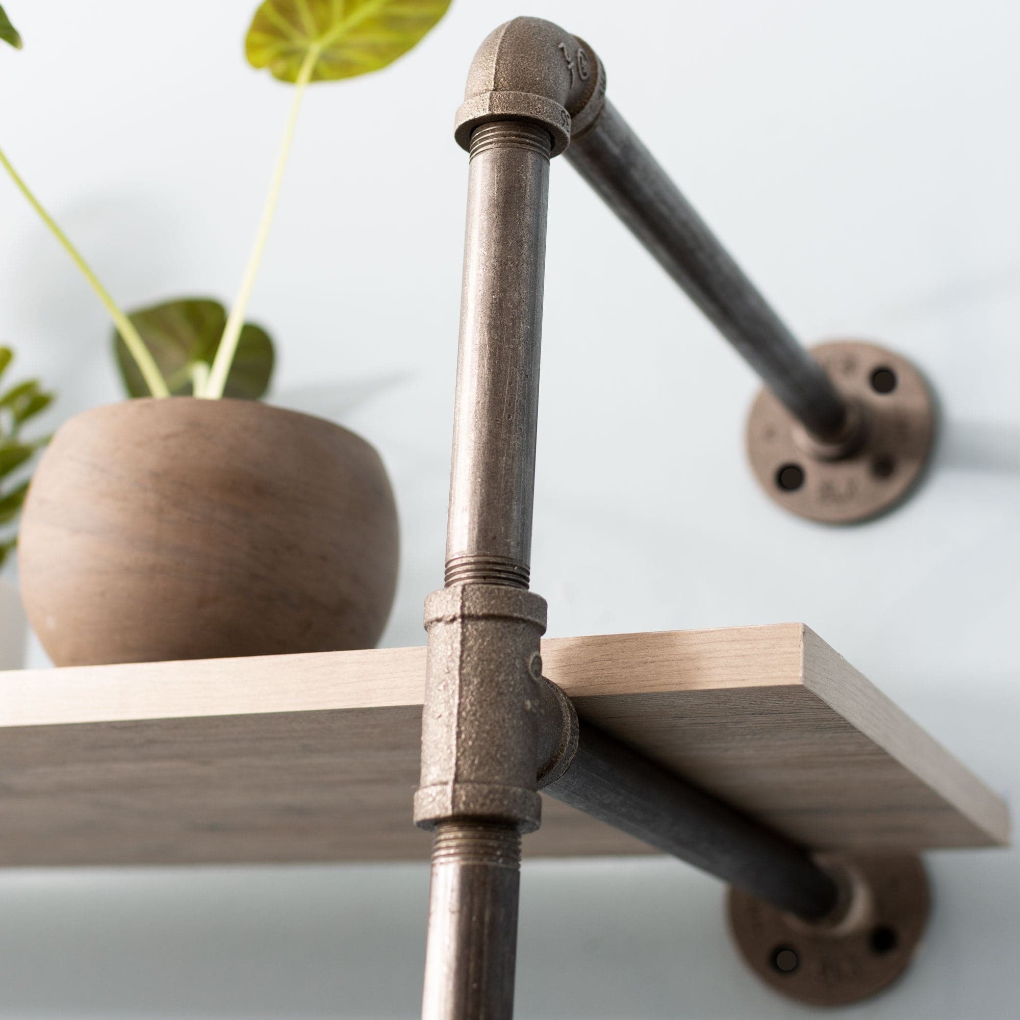 Two-tier wall-mounted shelf with black metal pipe brackets from Pipe Decor, showcasing a modern industrial design.