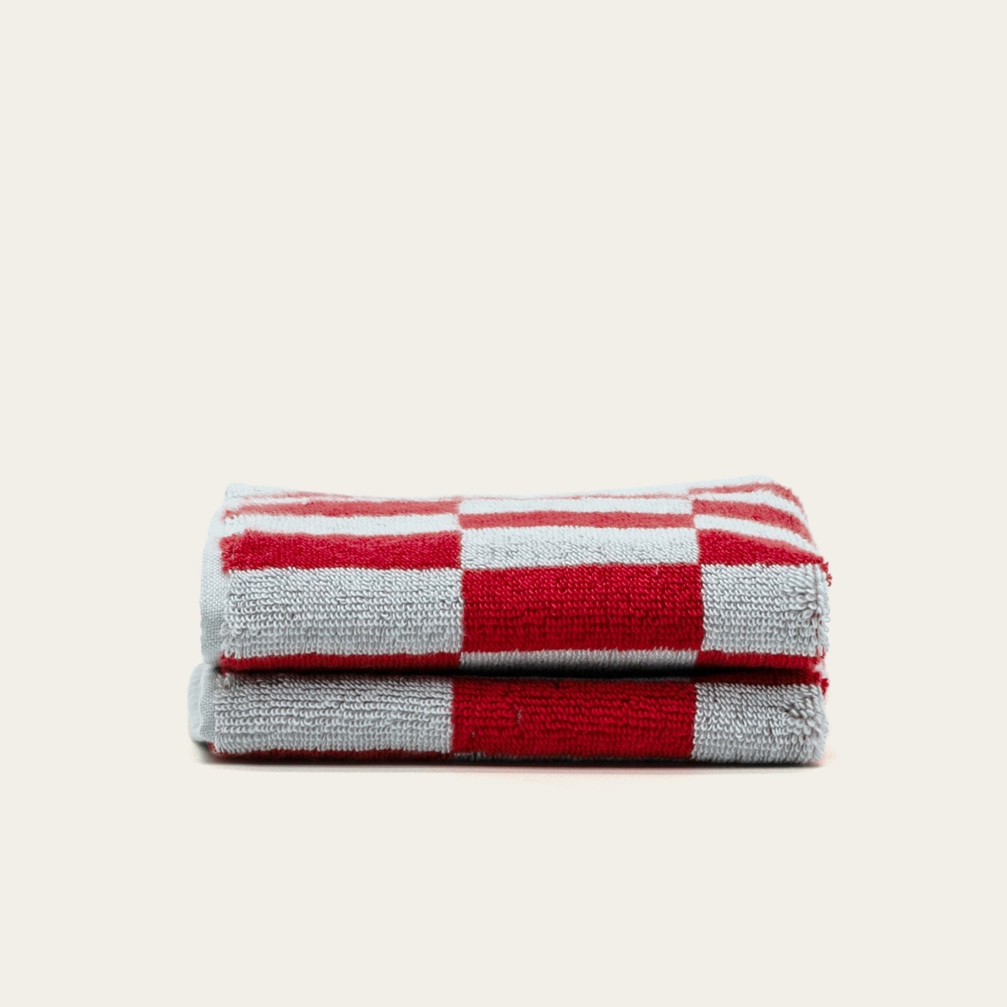 Soft, white Pietra Australian cotton towels by Italic with a textured weave, draped on a wooden surface.