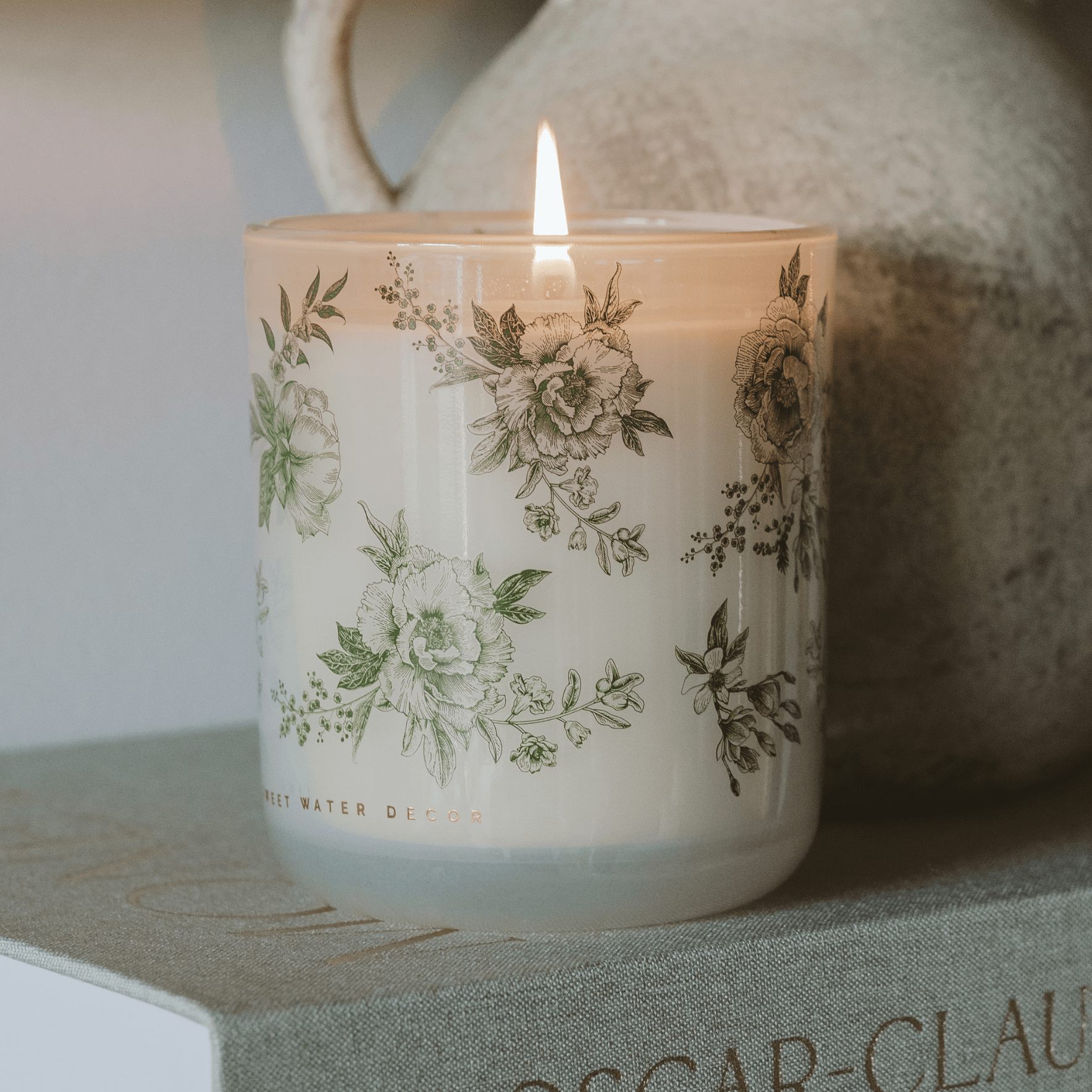 Green floral soy candle in a white tinted glass jar, 12 oz, with lavender and sage scent from Sweet Water Decor.