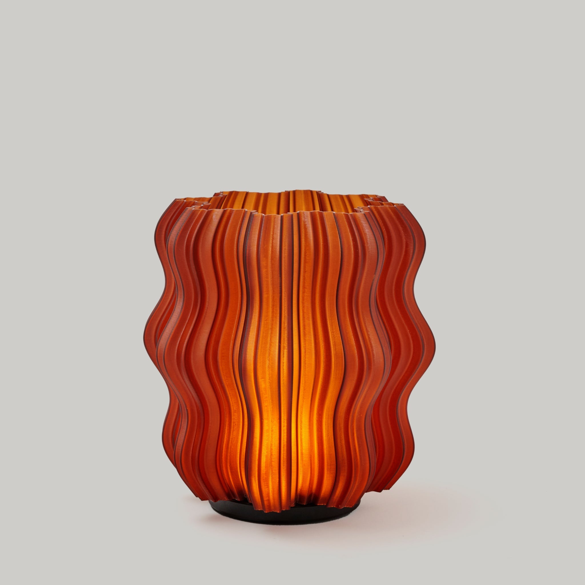 Wooj Design cordless mini wavy lamp with a sleek, amber-colored, wavy silhouette resting on a surface.