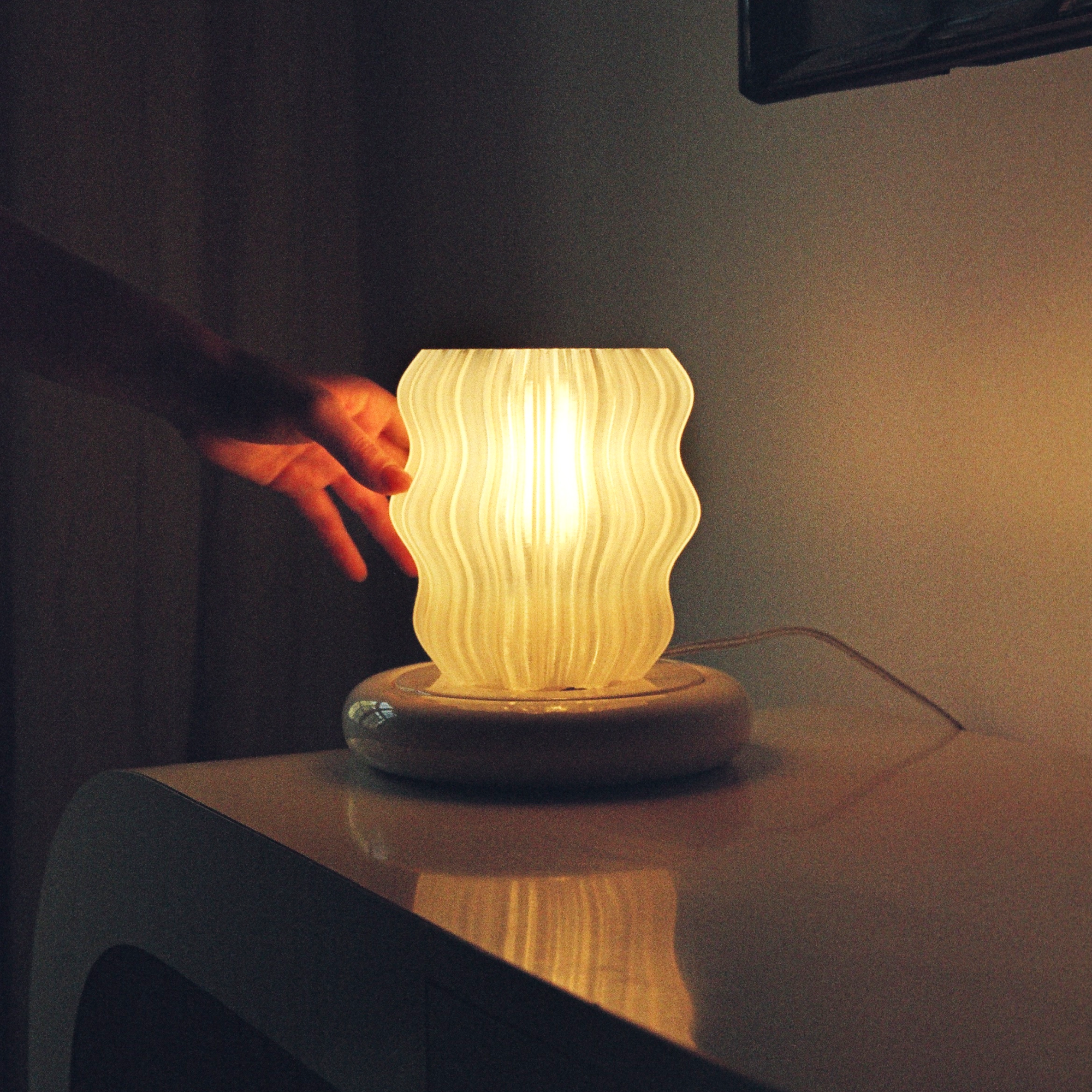Mini wavy lamp by Wooj Design featuring a sleek, modern design with a wavy shape and soft lighting effect.