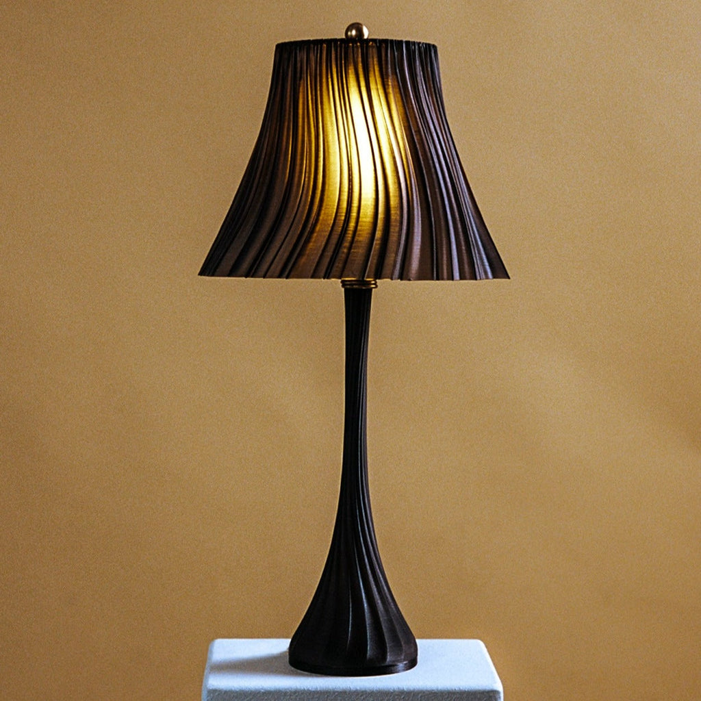 Wooj Design pleat lamp with a modern, ruffled fabric shade and sleek base, providing ambient lighting in a stylish interior setting.