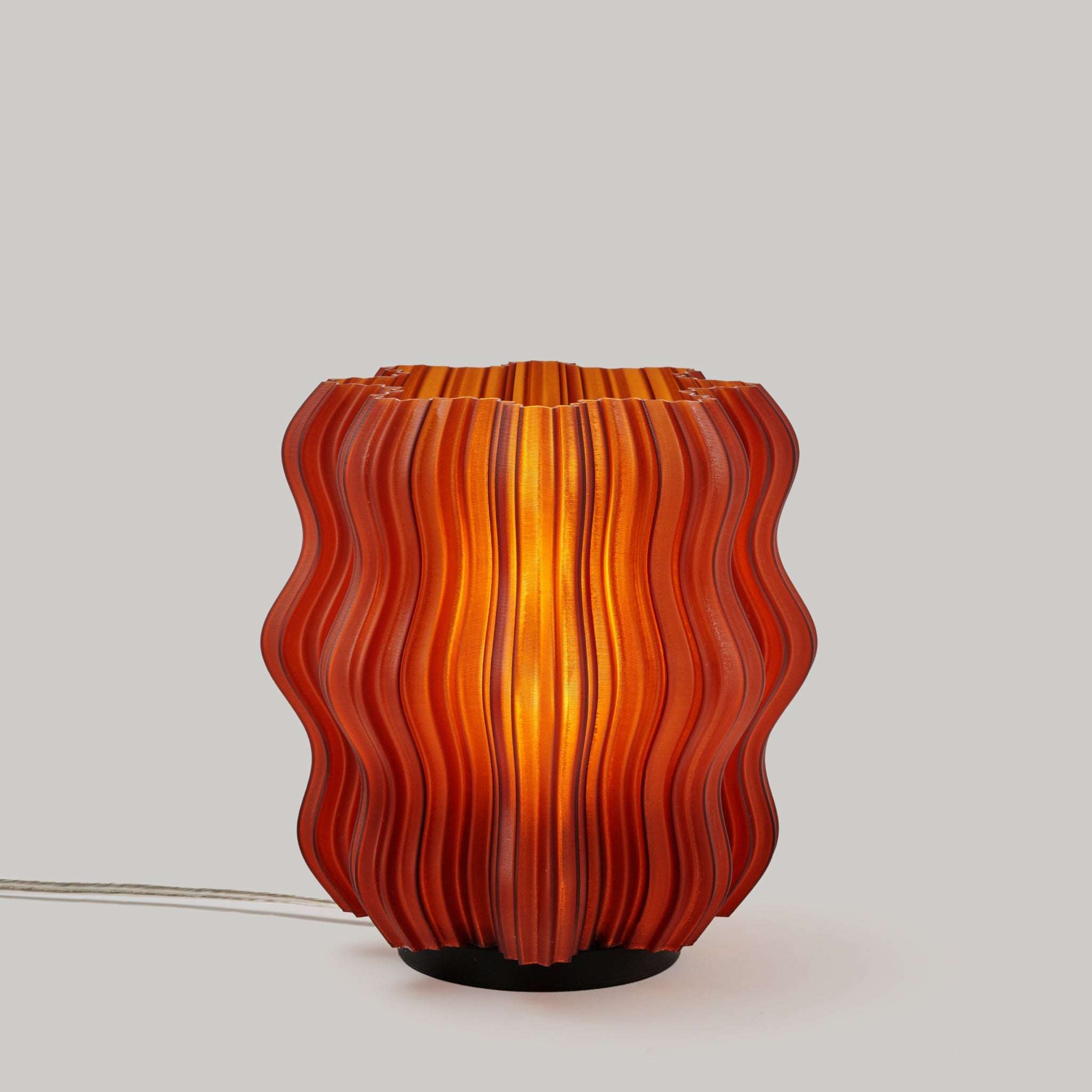 Mini Wavy Lamp by Wooj Design featuring a sleek, amber-colored wavy silhouette with a modern, artistic design.