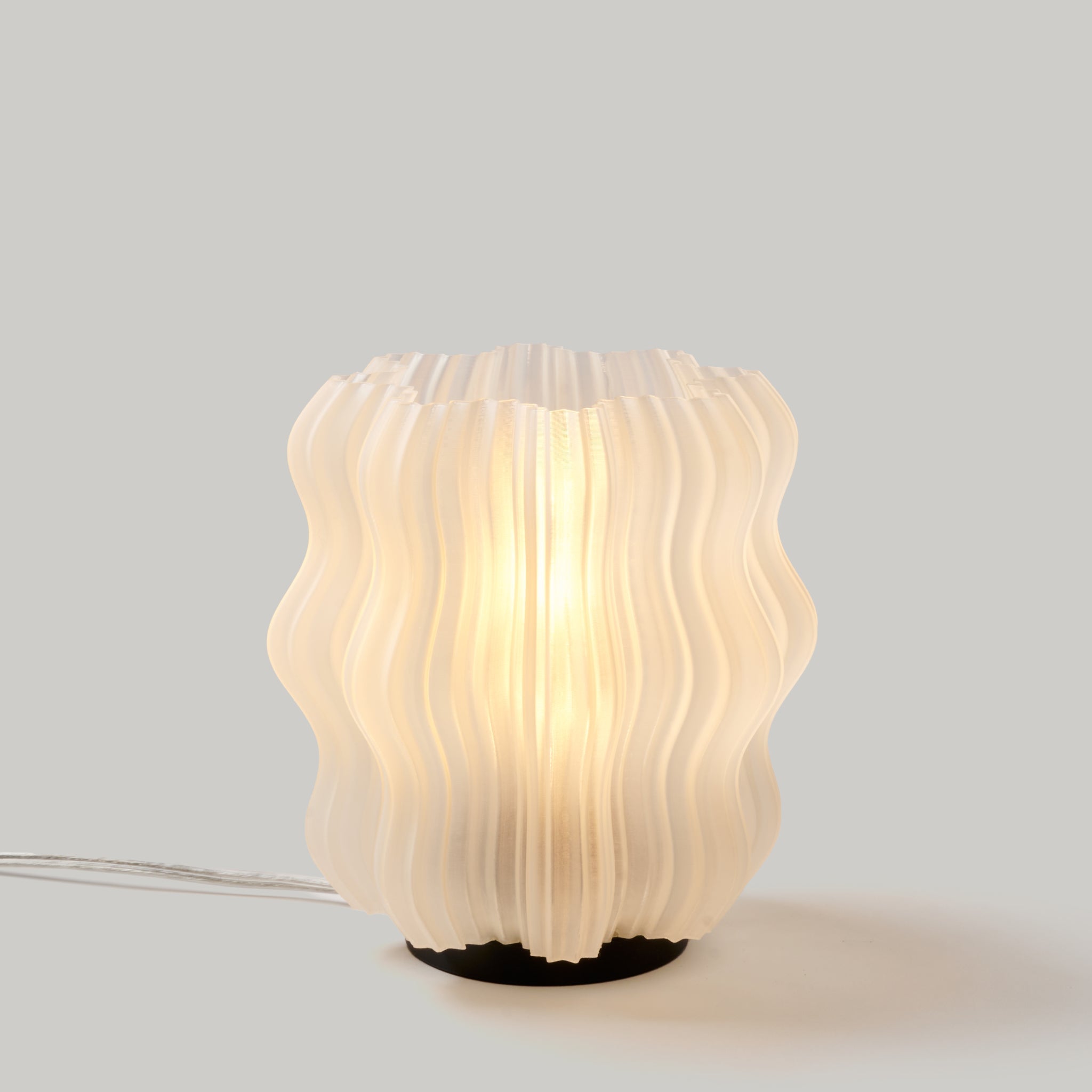 Wooj Design Mini Wavy Lamp in natural finish, showcasing a sleek, wavy ceramic design perfect for modern home decor.