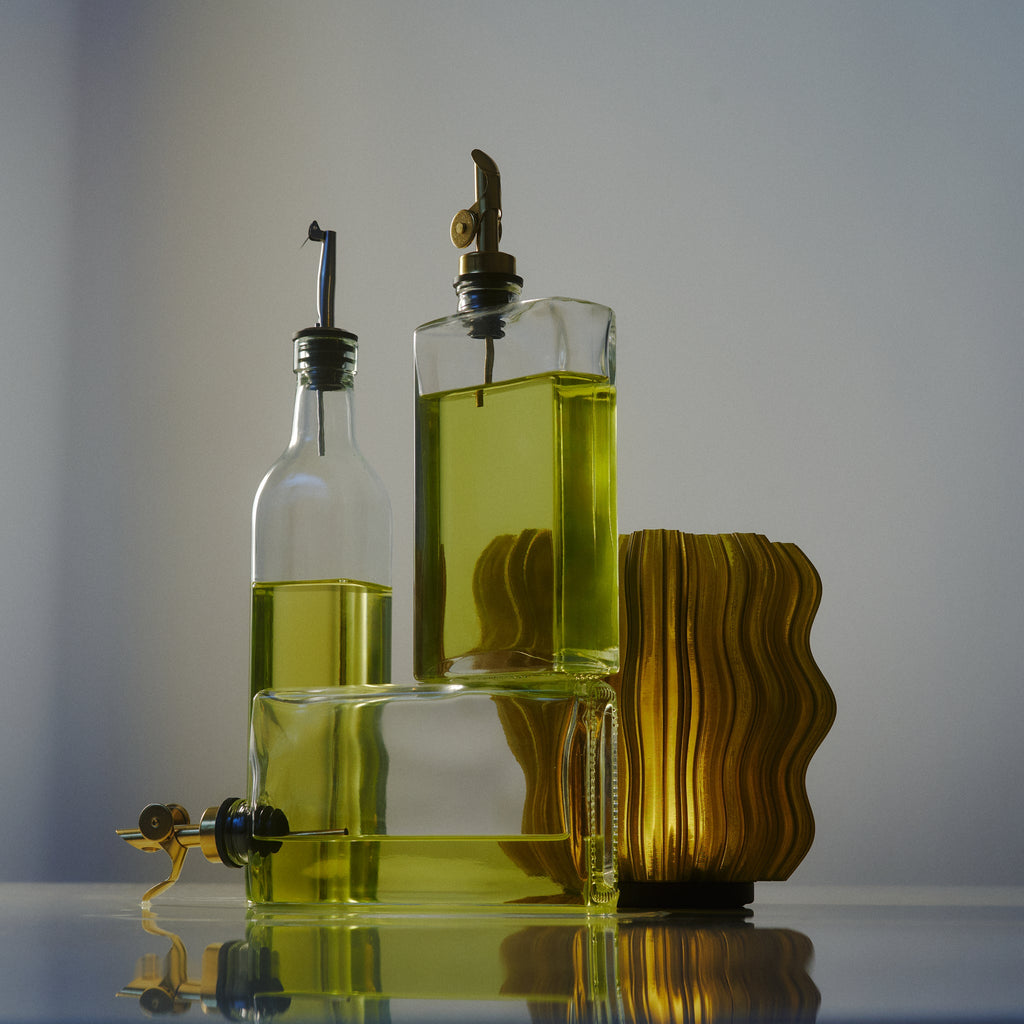 Mini Wavy Lamp by Wooj Design illuminated in olive oil color, showcasing its wavy shape and modern aesthetic.