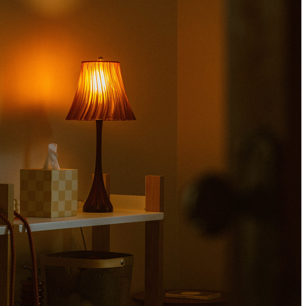 Wooj Design Pleat Lamp with amber pleated fabric shade, modern table lamp with textured design and warm lighting.