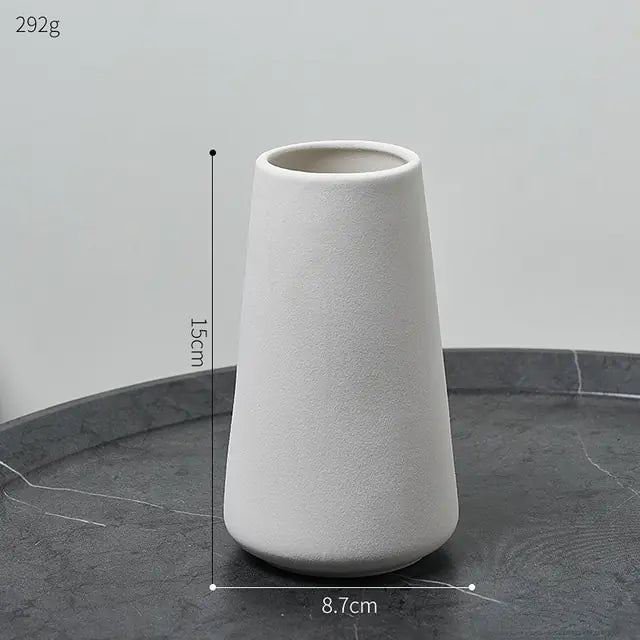 Simple ceramic vase in Nordic style with a smooth finish, white color, and minimalist design suitable for modern home decor.
