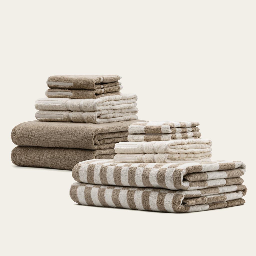 Family set of Pietra Australian Cotton Towels by Italic, showcasing soft, plush towels in various sizes on a bathroom shelf.