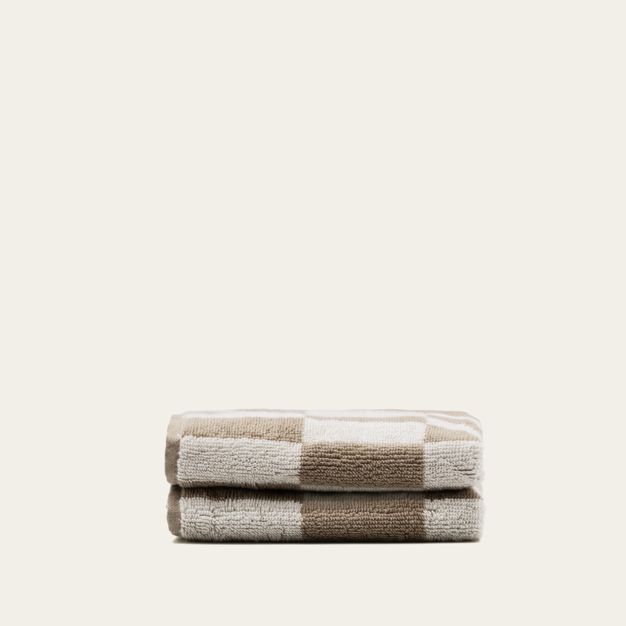 Cream-colored Pietra Australian cotton washcloth from Italic, soft and plush fabric with a textured woven surface.