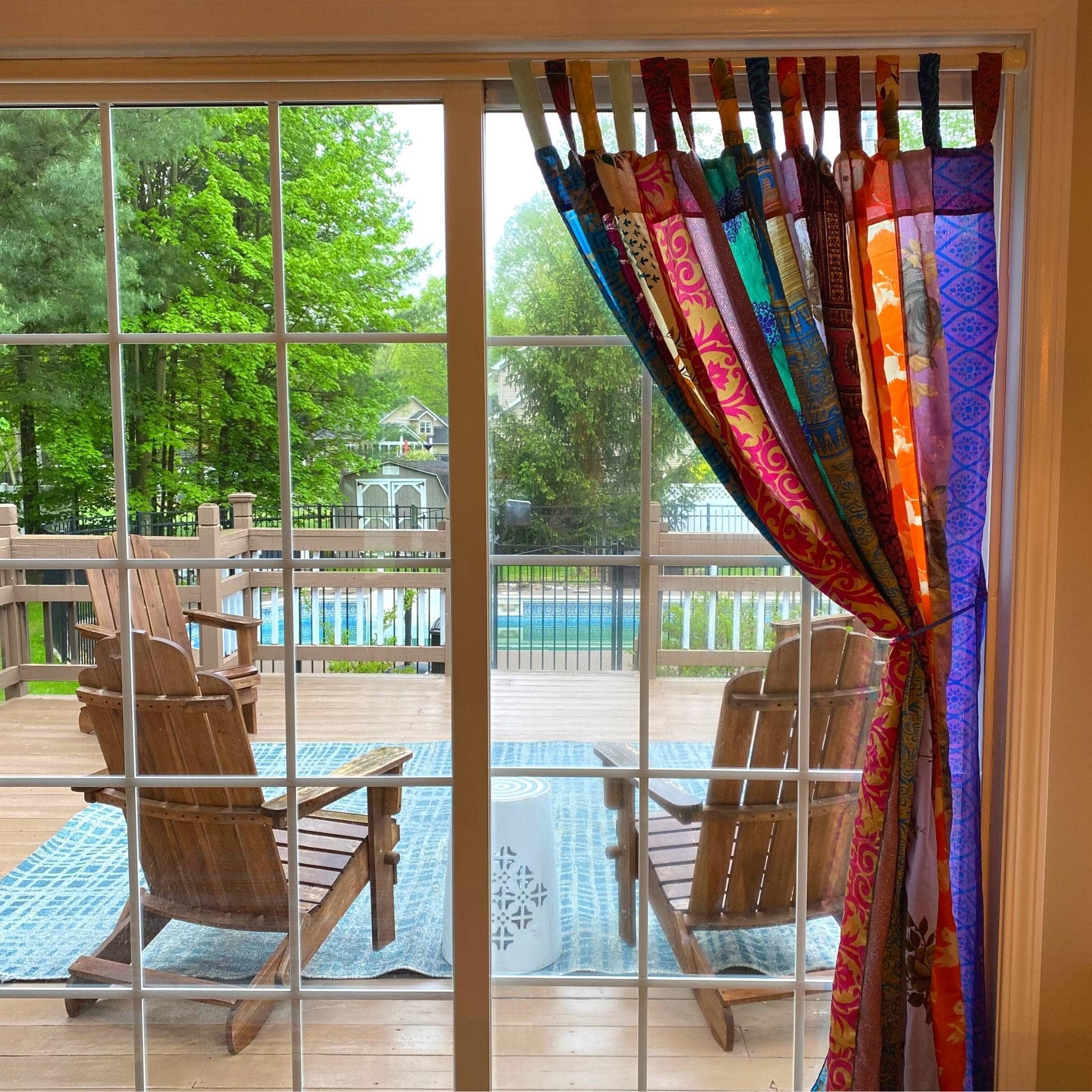 Colorful Rainbow Oasis boho curtains made from recycled sari fabric, perfect for outdoor patio decor, by Darn Good Yarn.