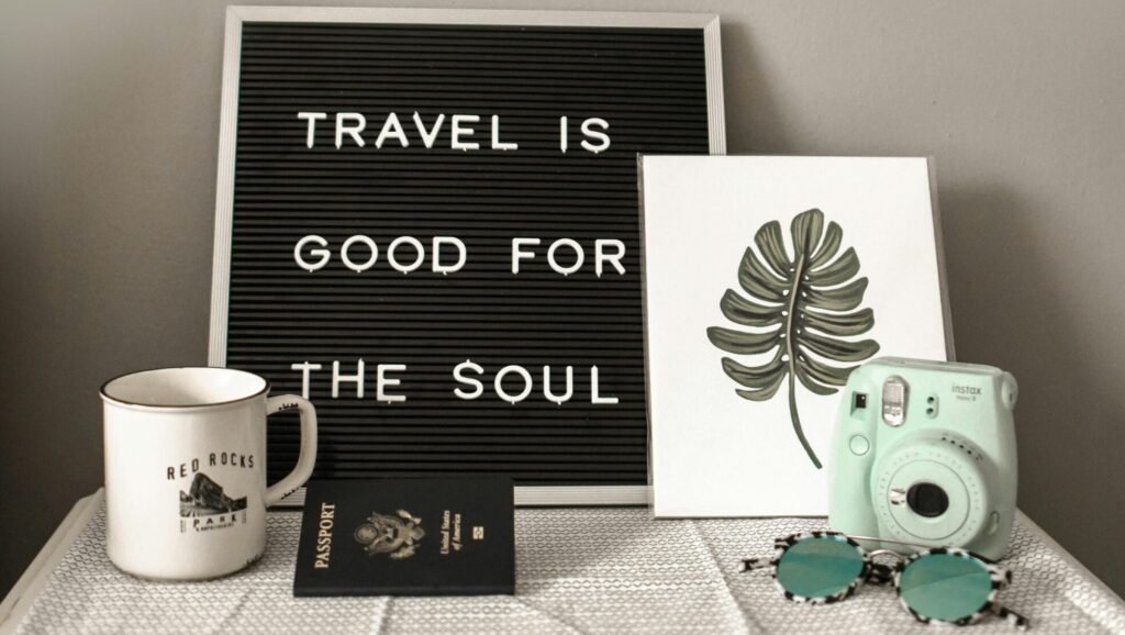 A travel-themed flat lay with a camera, coffee, and motivational quote.