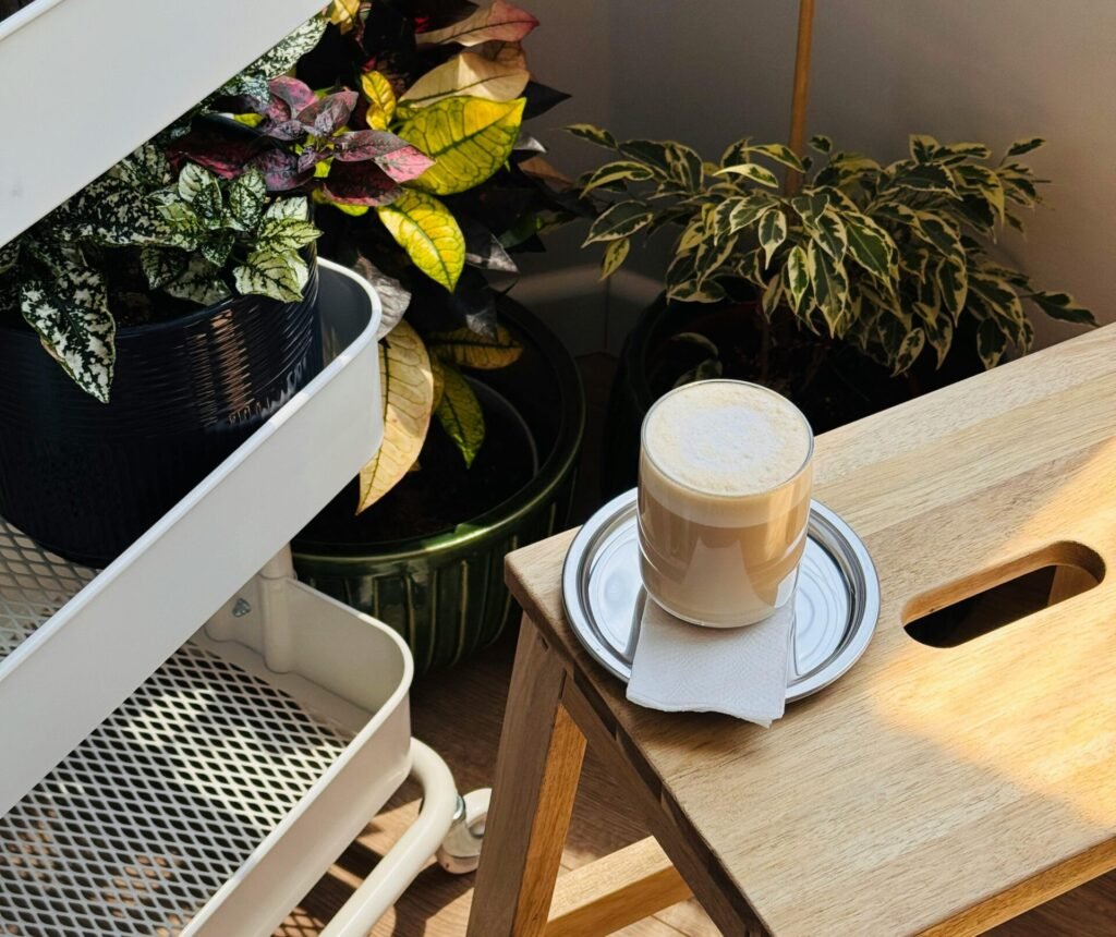 Inviting indoor scene featuring a latte and lush houseplants in natural light.