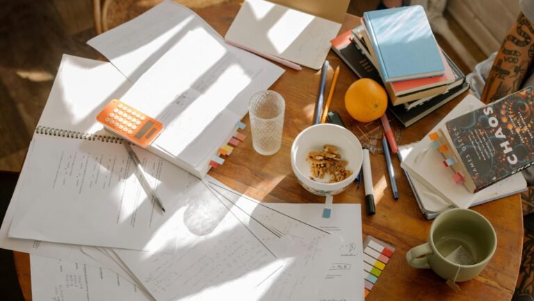 A cluttered study table with books, notes, and study materials in natural light for focused exam preparation.